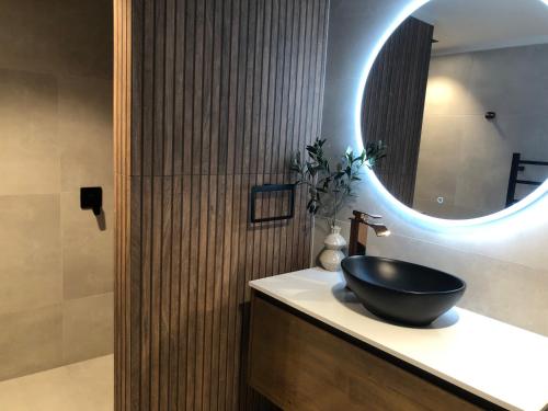 a bathroom with a black sink and a mirror at Vista - touch of country and spa in Havelock North