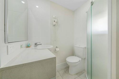 ein Bad mit einem WC, einem Waschbecken und einer Dusche in der Unterkunft Deluxe King Studio + top floor sea views in Emu Park