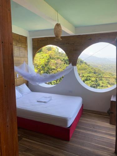1 dormitorio con 2 ventanas redondas y 1 cama en Puerto Alto, en Santa Marta