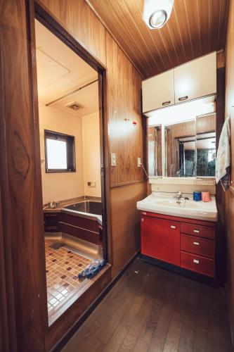 a bathroom with a tub and a sink and a mirror at 唐風家 北田辺 近邻地铁 3階 in Osaka
