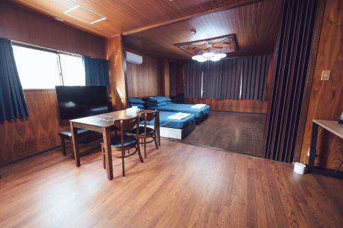 a living room with a table and a bed at 唐風家 北田辺 近邻地铁 3階 in Osaka