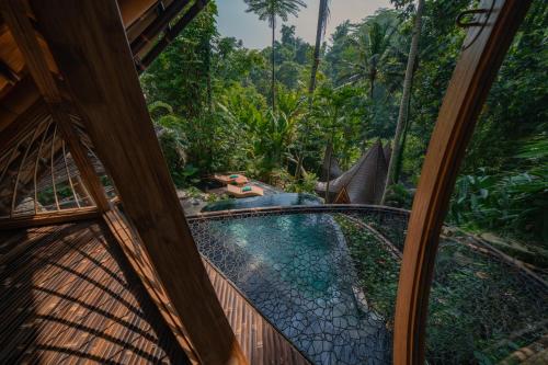 a room with a view of a balcony with a pool at Suenyo Eco Retreat in Tabanan