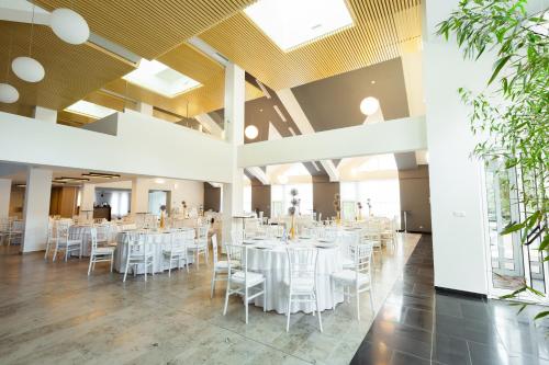 a banquet hall with white tables and chairs at Hotel Bistrita in Bistriţa
