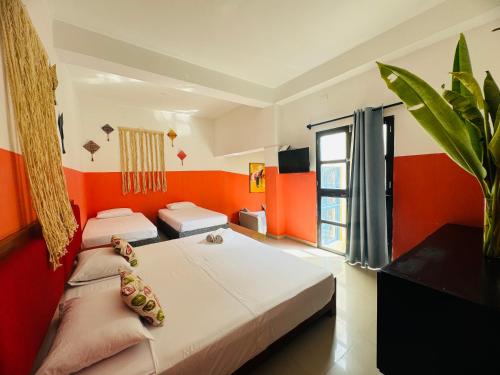 2 łóżka w pokoju z pomarańczowymi ścianami w obiekcie CASA ENCANTADA w mieście Santa Marta