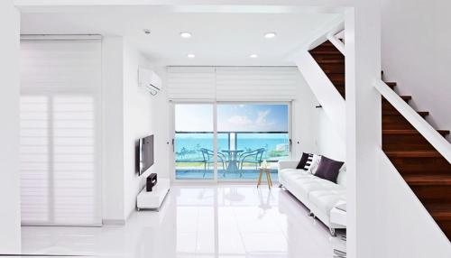 a white living room with a couch and a view of the ocean at Glories Pension in Buan