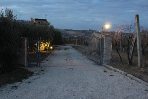 a road with a fence and a gate at night at La Casa nell'Orto in Fermo