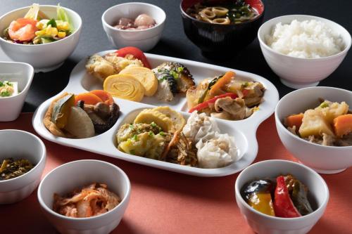 a table with several dishes of different types of food at Hotel Vista Kumamoto Airport in Ozu