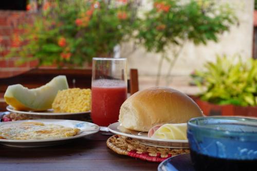 a table with plates of food and a glass of juice at Mar Aberto_chale 3 in Barroquinha