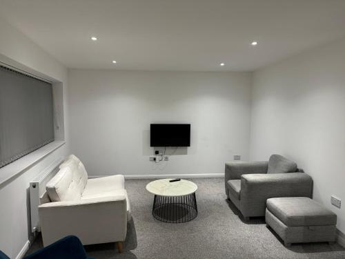 a living room with two chairs and a flat screen tv at Apartology Manchester in Manchester