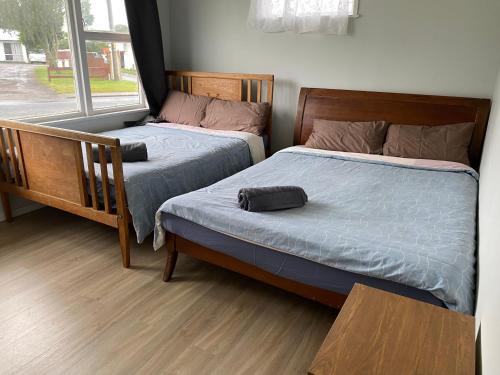 two twin beds in a room with a window at Your Home in Rotorua 3 Frank Street in Rotorua
