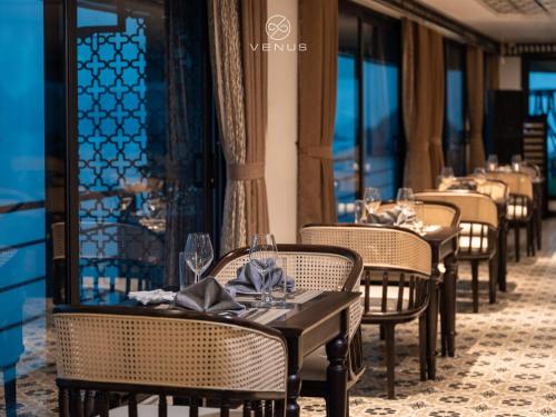 a row of tables and chairs in a restaurant at Venus Cruises Halong Bay in Ha Long