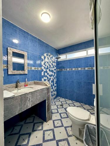 a blue bathroom with a sink and a toilet at Huerta Don Felipe in Irimbo