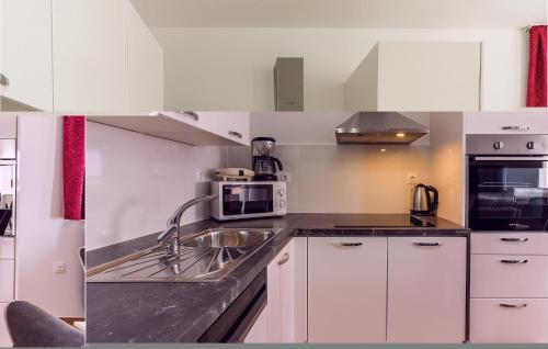 a kitchen with a sink and a microwave at Three-Bedroom Apartment In Medulin in Medulin