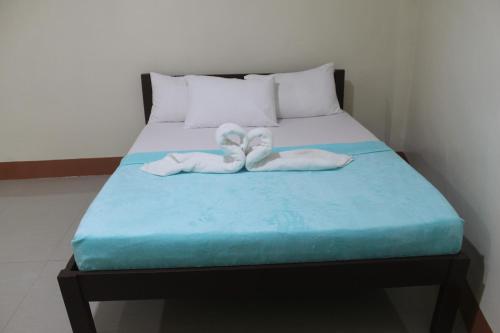 a bed with two towels on top of it at JUNLYN APARTELLE in Panglao Island