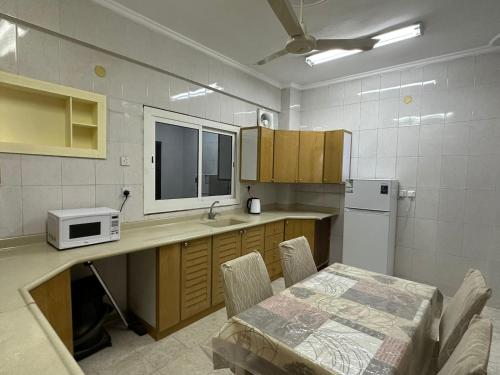 a kitchen with a table and a microwave at شقة مطلة على قباء in Medina