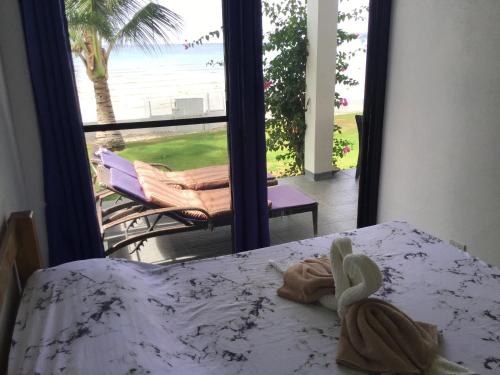sypialnia z łóżkiem i widokiem na ocean w obiekcie BambooBeachVilla1 AC New OCEANFRONT POOL sunsetview garden kitchen SATELLITE STARLINK WI-FI w mieście Dimiao