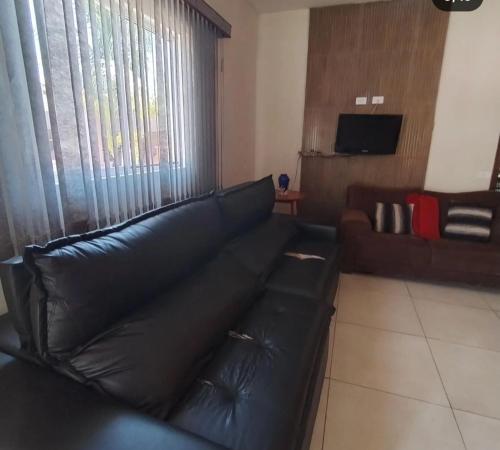 un sofá de cuero negro en la sala de estar en RANCHO SAO PEDRO (FARTURA), en Fartura