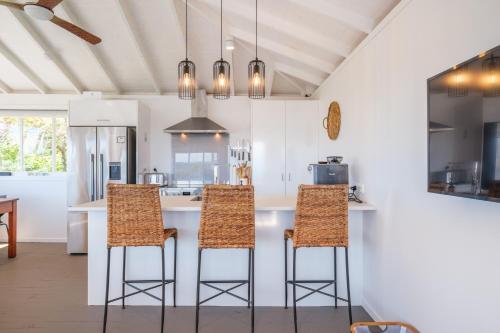 a kitchen with a counter with three bar stools at Gulf Island Views in Palm Beach