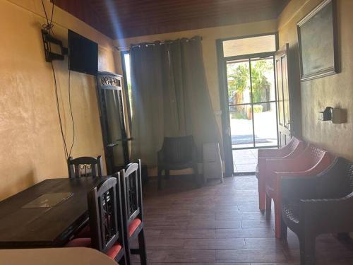 d'une salle à manger avec une table, des chaises et une fenêtre. dans l'établissement Casa Sendero, à Liberia