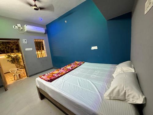 a blue bedroom with a bed with a blue wall at Arunachala Sashwin Guest House in Tiruvannāmalai