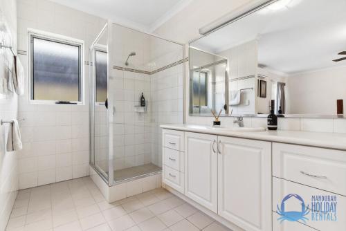 uma casa de banho branca com um chuveiro e um lavatório. em Hakuna Matata on Kiap in Yunderup em South Yunderup