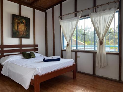 1 dormitorio con cama y ventana grande en Sand Castle Ocean Suites, en Zorritos