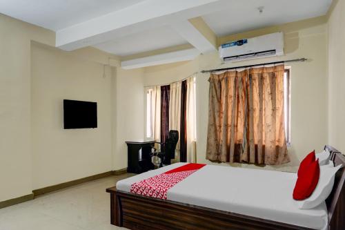 a bedroom with a bed and a television and a window at A S Hotels Ranchi in Rānchī