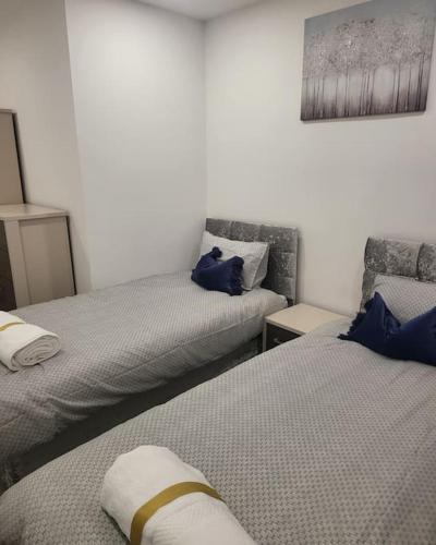 a room with two beds and a chair in it at 2 Bedrooms 2Baths 3Toilets near Excel City Airport O2 Sleeps up to 5 in London