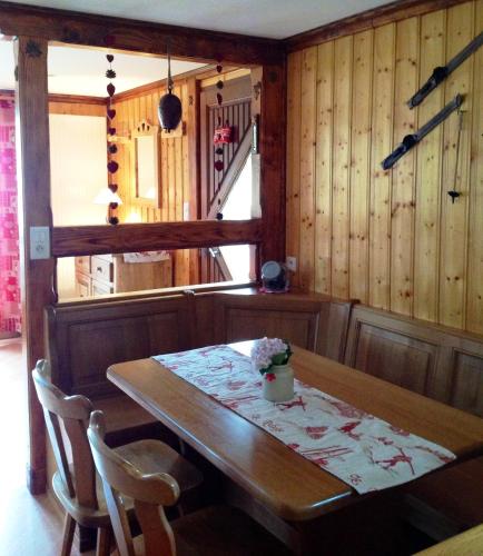 une salle à manger avec une table et des chaises en bois dans l'établissement Les Bouquetins, à Stosswihr