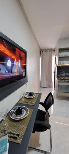 uma sala de estar com uma mesa e uma televisão em Loft 3 Novo 5 min aeroporto Marabá em Marabá