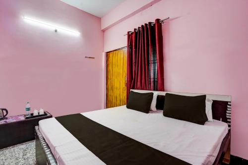 a bedroom with a large bed with pink walls at OYO Flagship Hotel Radhe Inn in Juhi Bari