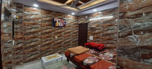 una camera con un muro in pietra e un divano di Luxury flat in foreigner areof lajpat nagar with fully equipped kitch a Nuova Delhi