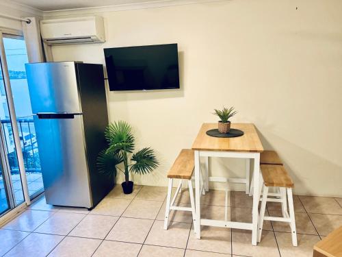 a kitchen with a table and a refrigerator at River Sands Apartments in Maroochydore