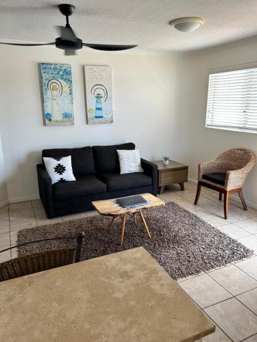a living room with a black couch and a table at River Sands Apartments in Maroochydore