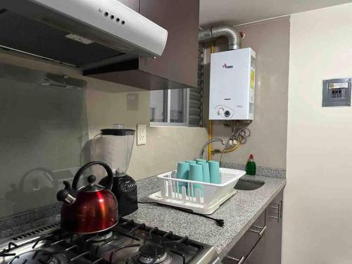 a kitchen counter with a tea kettle on a stove at Apartamento cerca autódromo in Mexico City