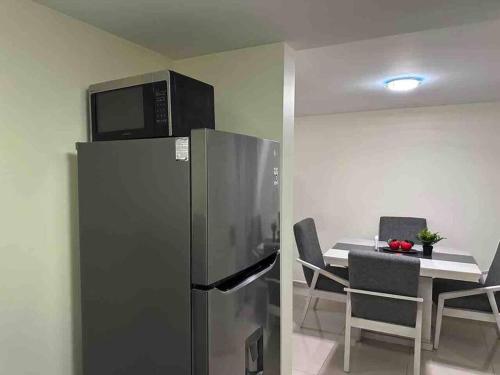 a kitchen with a refrigerator and a table with chairs at Apartamento cerca autódromo in Mexico City