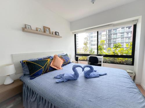 dois bichos de peluche estão sentados numa cama em Apartamento exclusivo a 70 metros de san Isidro em Lima