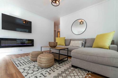 a living room with a couch and a tv at Where We Roam Log Cabin with Mountain Views in Kellogg