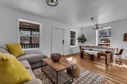 a living room with a couch and a piano at Where We Roam Log Cabin with Mountain Views in Kellogg