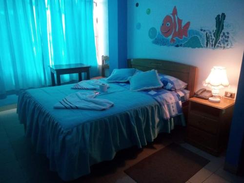 a blue bedroom with a bed with blue sheets at Hotel Bethania in Oruro