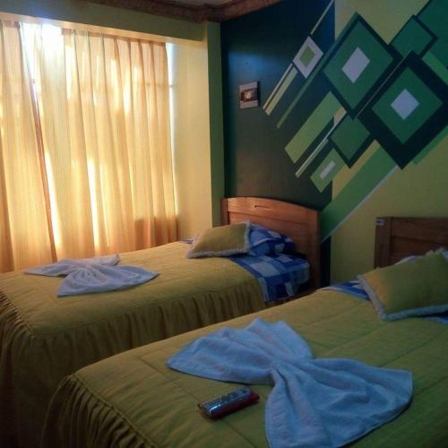 2 camas con toallas encima de ellas en un dormitorio en Hotel Bethania, en Oruro