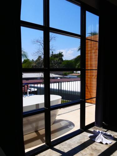 a window with a view of a bath tub outside at Book a Bed Poshtel - SHA Plus in Phuket Town