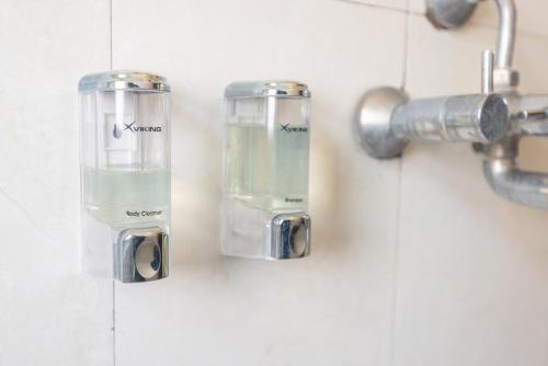 a bathroom with two soap dispensers on a wall at Hotel Yambu kathmandu in Kathmandu