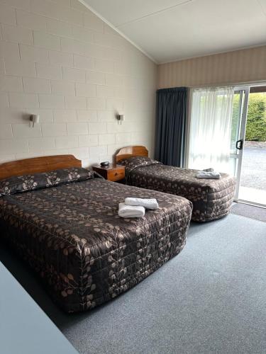 una camera d'albergo con due letti e una finestra di Helensborough Motor Inn a Balclutha