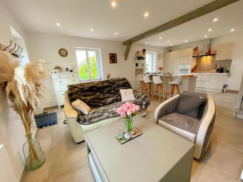 un salon avec un canapé et une table dans l'établissement Gîte tout confort avec terrasse spacieuse, jardin clos et équipements modernes, à 45 mn du Mans - FR-1-381-557, à Saint-Aubin-le-Dépeint