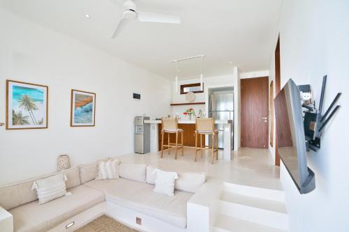 a white living room with a couch and a table at Pagi Villas by Betterplace in Canggu