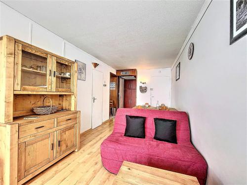 - un salon avec un canapé rose et une armoire en bois dans l'établissement Appartement lumineux · Ski aux pieds · Centre station · Près des commerces et ESF - FR-1-267-277, à La Toussuire