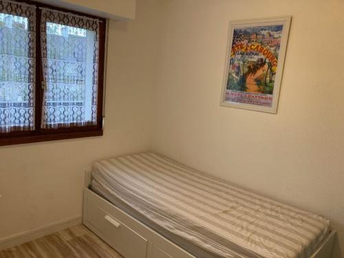un lit dans une chambre avec une fenêtre dans l'établissement Agréable 2 pièces avec balcon près de la plage - 4 pers, calme, stationnement gratuit - FR-1-712-74, à Villers-sur-Mer