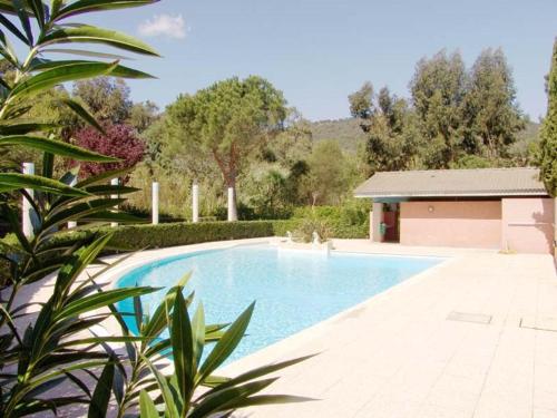 une piscine dans une cour avec une maison dans l'établissement Appartement 2 pièces cabine avec terrasse, jardin, piscine et parking, proche plage - Le Lavandou - FR-1-251-517, au Lavandou