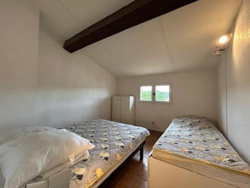 une chambre avec deux lits et une fenêtre dans l'établissement Sainte-Maxime : Appartement lumineux 2 pièces avec parking dans résidence calme - FR-1-226-536, à Sainte-Maxime
